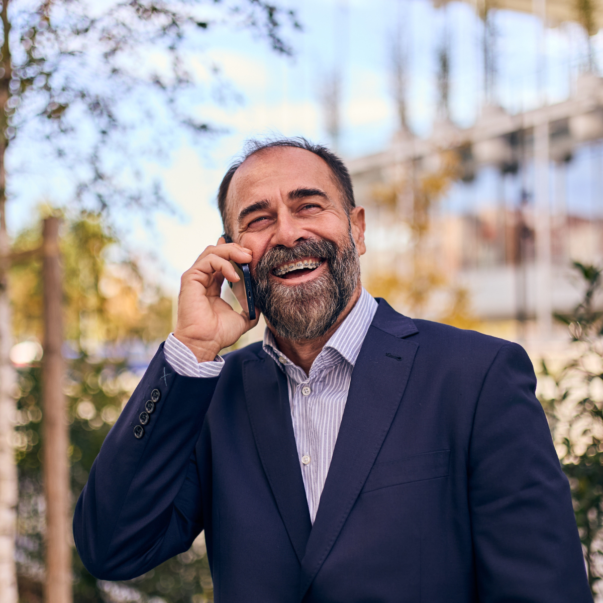 A confident executive laughing on a call , at ease and in control