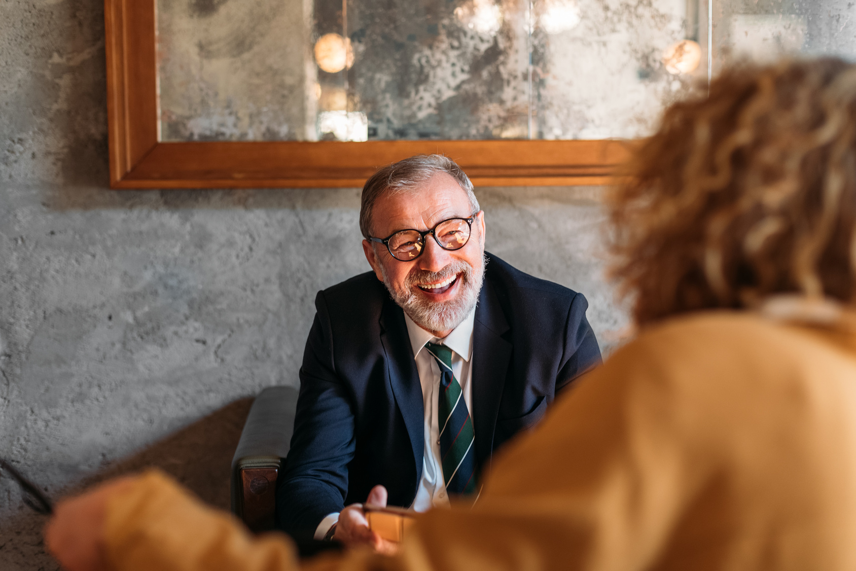 A senior executive sharing a warm moment at a meeting
